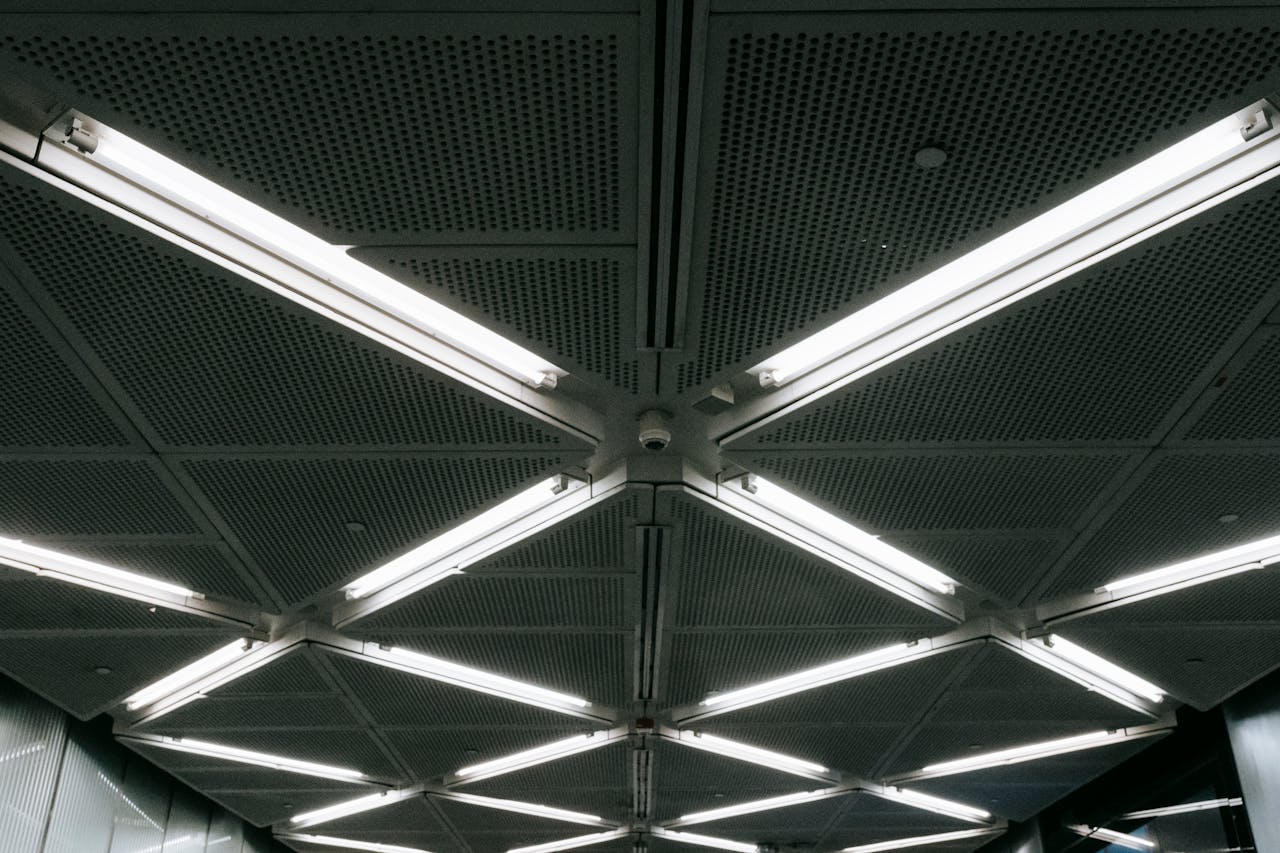 A modern indoor ceiling featuring geometric patterns and bright LED lighting.