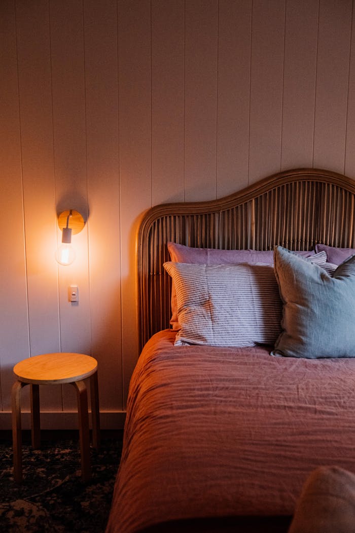 who-we-are Warm and inviting bedroom interior with stylish bedding and ambient lighting. Perfect for home decor inspiration.